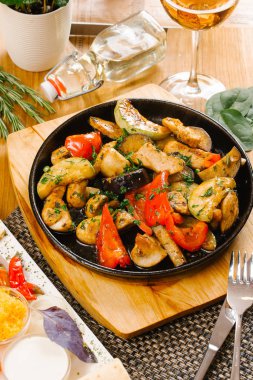 kızarmış patates, sebze ve ahşap tahta üzerinde hizmet domuz eti ile sıcak tava görünümünü kapat