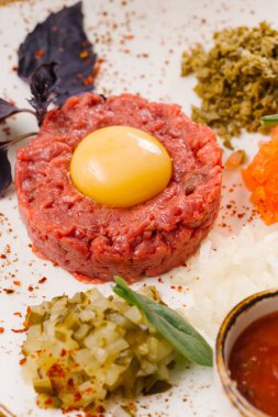 Çiğ et hamur doğranmış Turşu sebze ve domates sosu ile servis yumurta sarısı ile görünümü Kapat 