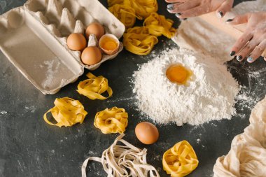 Kadının fettuccine makarna hamur siyah masaya haddeleme görünümü Kapat 