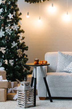 Noel ağacı ile odada küçük masada mandalina 