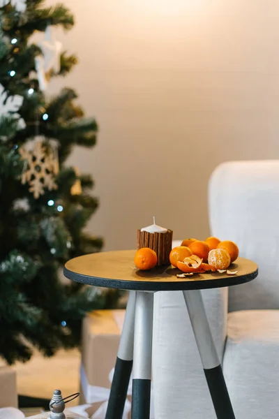 mandarins on small table against Christmas tree