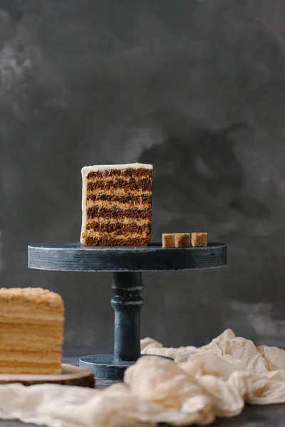 close up view of cut cake pieces on cake stand on grey backdrop