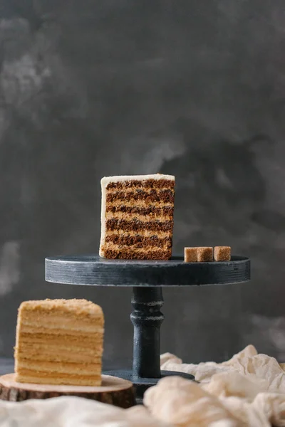 close up view of cut cake pieces on cake stand on grey backdrop