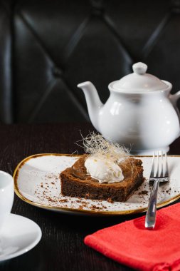 plaka ve çaydanlık siyah masa üzerinde tatlı çikolatalı kek görünümünü kapat