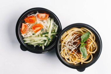 Beyaz arka planda siyah kaplarda sağlıklı gıda üstten görünüm