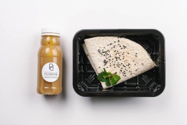 Kutusunda tortilla ve güler yüzlü şişe doğru beslenme beyaz arka plan üzerinde yukarıdan