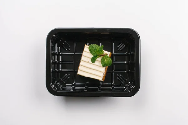 Top view of proper nutrition with piece of cake in box on white background