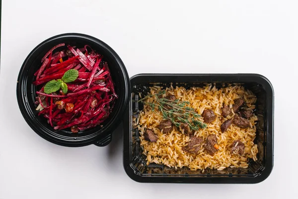 Beyaz arka plan üzerinde pirinç ve et ile pancar salatası kutularındaki üstten görünüm