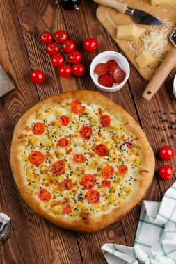 ahşap masa üzerinde beyaz sos, peynir ve dilimlenmiş domates ile pişmiş pizza üstten görünüm