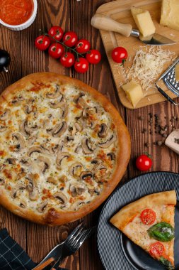 ahşap masa üzerinde beyaz sos, peynir ve dilimlenmiş mantar ile pişmiş pizza üstten görünüm