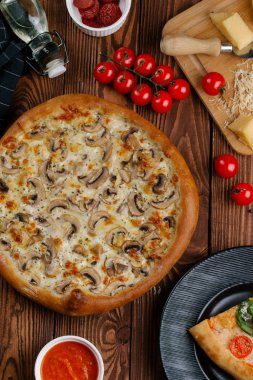 ahşap masa üzerinde beyaz sos, peynir ve dilimlenmiş mantar ile pişmiş pizza üstten görünüm
