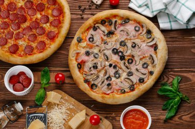 iki pişmiş pizza üstten görünüm ahşap tablo