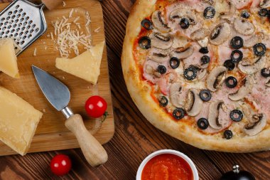 pişmiş Pizza domates sosu, peynir, dilimlenmiş jambon, mantar ve zeytin üstten görünüm