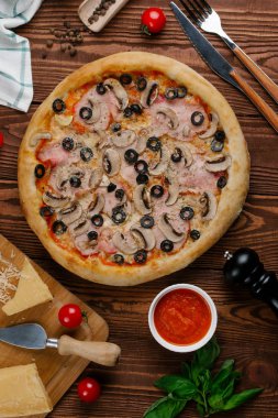 pişmiş Pizza domates sosu, peynir, dilimlenmiş jambon, mantar ve zeytin üstten görünüm