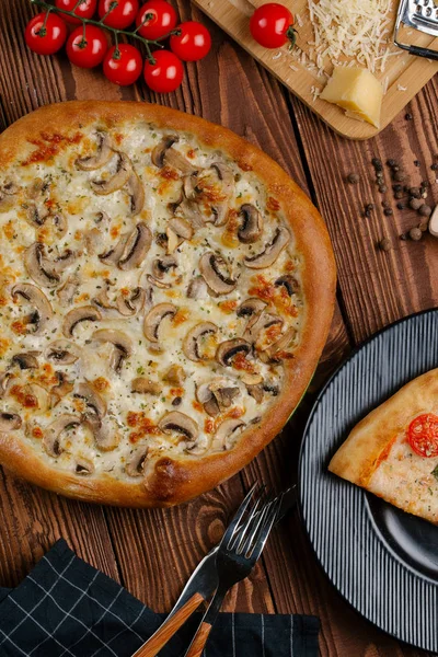 ahşap masa üzerinde beyaz sos, peynir ve dilimlenmiş mantar ile pişmiş pizza üstten görünüm