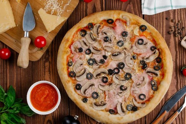 pişmiş Pizza domates sosu, peynir, dilimlenmiş jambon, mantar ve zeytin üstten görünüm