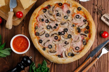 pişmiş Pizza domates sosu, peynir, dilimlenmiş jambon, mantar ve zeytin üstten görünüm