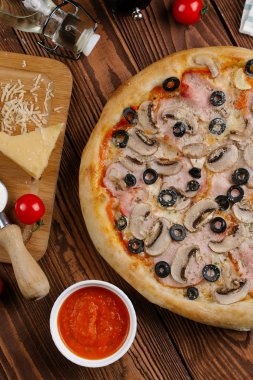 pişmiş Pizza domates sosu, peynir, dilimlenmiş jambon, mantar ve zeytin üstten görünüm
