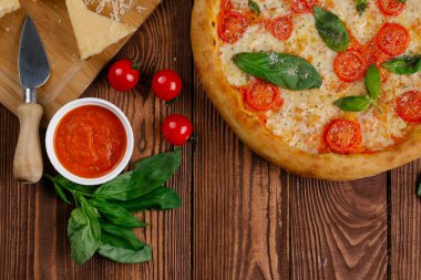 üstten görünüm Pizza domates, peynir ve taze fesleğen ile ahşap masaya servis bırakır