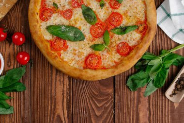 üstten görünüm Pizza domates, peynir ve taze fesleğen ile ahşap masaya servis bırakır