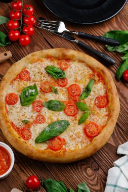 üstten görünüm Pizza domates, peynir ve taze fesleğen ile ahşap masaya servis bırakır