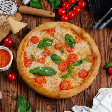 üstten görünüm Pizza domates, peynir ve taze fesleğen ile ahşap masaya servis bırakır