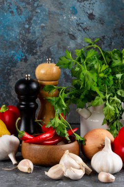 Otlar ve baharatlar karanlık kayrak masada. Maydanoz, dereotu, sarımsak ve biber. Yemek pişirmek için malzemeler