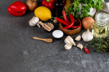 Otlar ve baharatlar karanlık kayrak masada. Maydanoz, dereotu, sarımsak ve biber. Yemek pişirmek için malzemeler