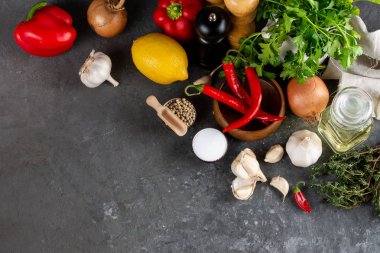 Otlar ve baharatlar karanlık kayrak masada. Maydanoz, dereotu, sarımsak ve biber. Yemek pişirmek için malzemeler