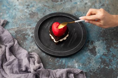 Koyu arka plan üzerinde kalp şeklinde lezzetli çikolatalı kek