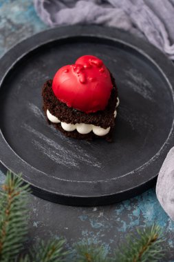 Koyu arka plan üzerinde kalp şeklinde lezzetli çikolatalı kek