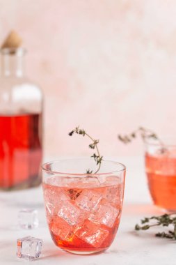 Otlar ve buz küpleri ile pembe ev yapımı limonata