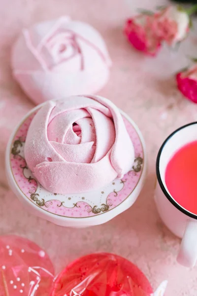 Pink homemade candies in rose shapes and candies on sticks