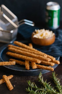 Kızarmış peynirli çubuk karanlık plaka üzerinde