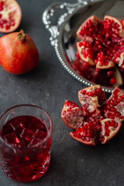 Bardak taze meyve suyu ve nar masada