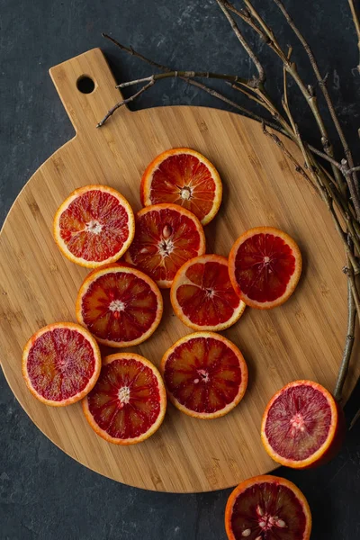 Fatias Laranja Vermelha Placa Madeira Fundo Escuro — Fotografia de Stock