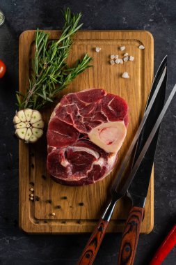 Otlar ve sarımsak ahşap tahta üzerinde çiğ biftek