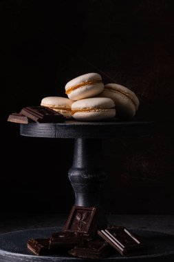 Çikolata ve koyu arka plan üzerinde macaroons