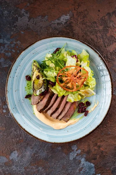 Sığır eti, yeşil yaprakları, kurutulmuş domates ve kızılcık ile salata