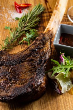 Ahşap tahta üzerinde servis edilen kemikte kavrulmuş et