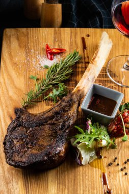 Ahşap tahta üzerinde servis edilen kemikte kavrulmuş et