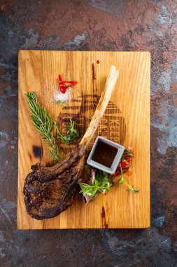 Ahşap tahta üzerinde servis edilen kemikte kavrulmuş et