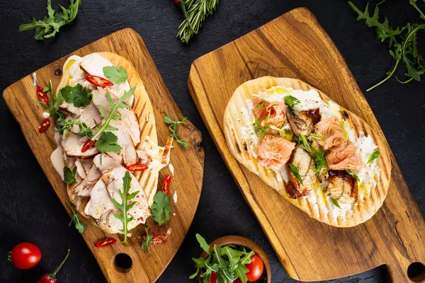 Starters with meat and fish with herbs and vegetables served on wooden boards