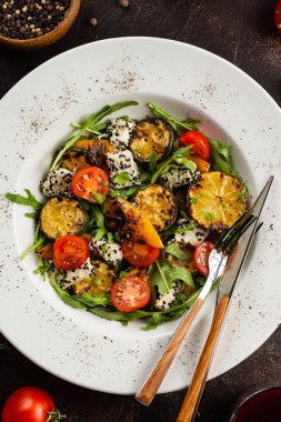 Beyaz tabakta peynirli taze sebze salatası ve ızgara limon