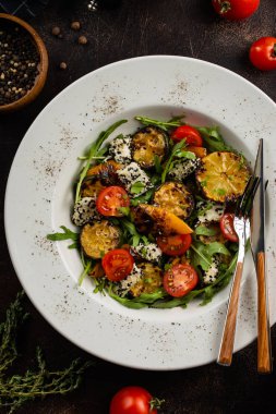 Beyaz tabakta peynirli taze sebze salatası ve ızgara limon