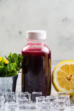 malzemelerle beyaz masa üzerinde şişe de taze sıkılmış berry suyu