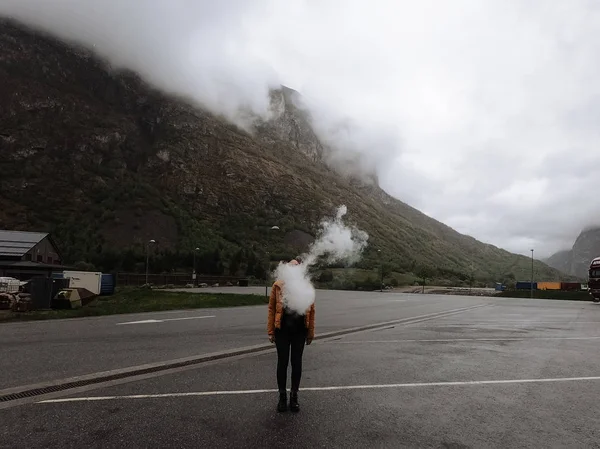 Female tourist with vapor breath in foggy landscape of wooded countryside of Oslo, Norway