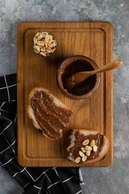 ahşap kesme tahtası üzerinde ekmek, fıstık ve çikolata krema parçası üst görünümü