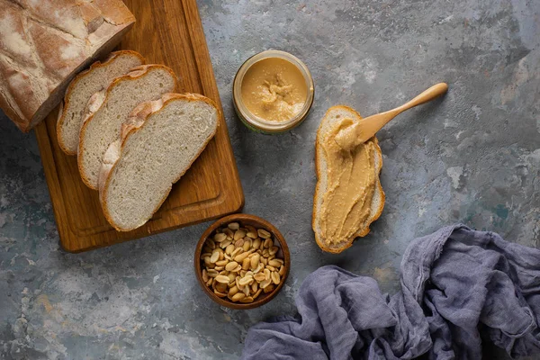 Ansicht Von Brot Auf Holzschneidebrett Und Erdnussbutter Auf Dunkelgrauer Tischplatte — Stockfoto