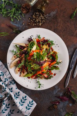 Paslı arka planda beyaz tabakta tavuk ile sebze salatası